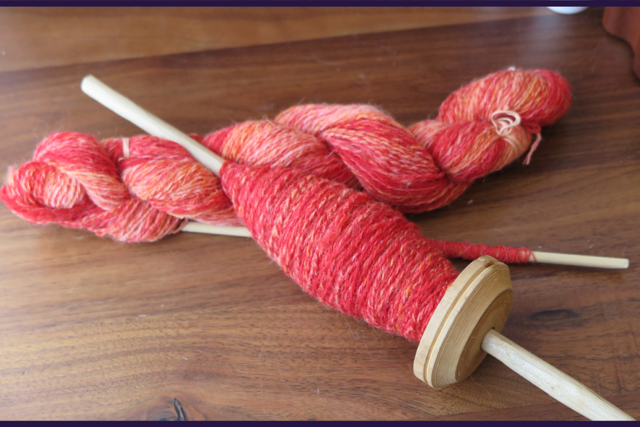 A skein of yarn and a cop on a spindle of the same pinkish orange tonal yarn spun in 3ply